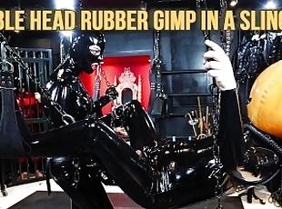 Bubble Head Rubber Gimp in a Sling - Heavy Rubber Dominatrix strap-on teaser