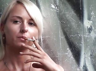 Lovely blonde teen smoking a cigarette outdoors by Femdom Austria